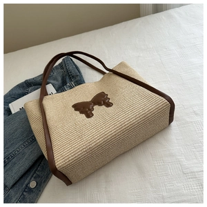 Detailed macro view of woven straw texture with leather bow and handles on a summer tote bag