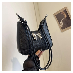 Detail of black woven crescent bag with silver bow buckle and knotted shoulder strap