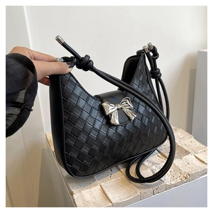 Detail of woven black leather hobo bag with metallic bow and knotted shoulder strap