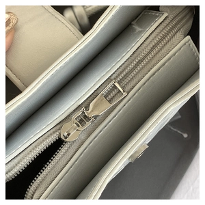 Detail view of smooth silver leather crescent bag with durable zipper and magnetic closure