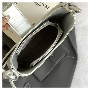 Detail view of woven shoulder bag interior showing grey lining and zipper compartment