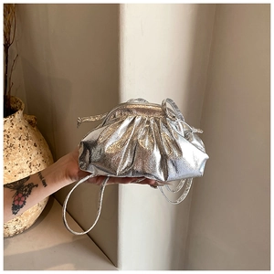 Detail shot of the silver metallic pleated cloud bag with natural ruched leather design