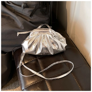 Close-up of a metallic silver pleated cloud bag showing glossy texture and fine folds