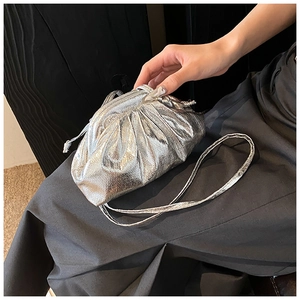Detailed close-up of metallic silver pleated pouch bag with cracked faux leather texture
