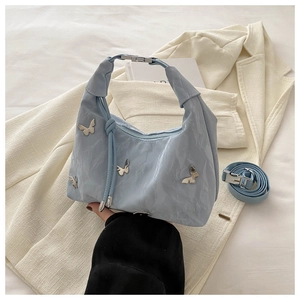Détail d'un sac à main plissé bleu clair avec papillons argentés et bandoulière réglable