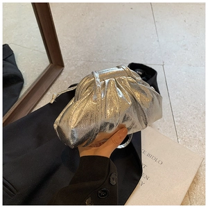 Close-up of metallic silver pleated cloud bag with soft ruched texture and slim strap
