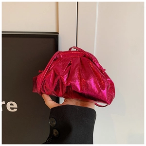 Close-up of fuchsia metallic pleated dumpling bag with adjustable shoulder strap