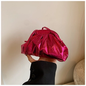 Close-up of metallic pink pleated cloud bag featuring glossy material and a hand-held design