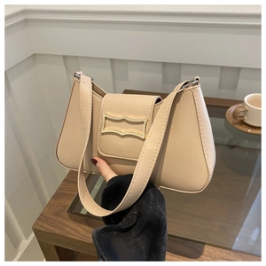 Détail du sac croissant beige montrant la boucle dorée et la texture du cuir raffiné
