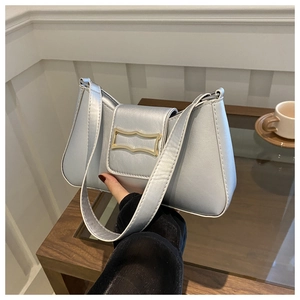 Détail du sac croissant argenté avec boucle dorée et surpiqûres blanches élégantes