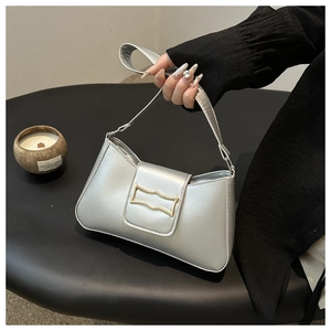 Détail du sac baguette argenté brillant avec une boucle dorée élégante et sophistiquée