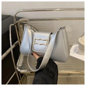 Vue détaillée du sac croissant argenté avec boucle dorée unique et fine bandoulière élégante