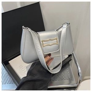 Détail d'un sac demi-lune argenté métallisé avec boucle dorée et texture en cuir PU