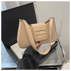 Détail d'un sac demi-lune beige avec boucle dorée en forme de vague sur fond minimaliste