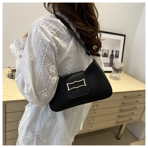 Sac sous le bras croissant noir chic avec fermoir doré dans un cadre de vie réel