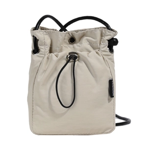 Minimalist beige crossbody phone bag with drawstring closure and fashion label tag