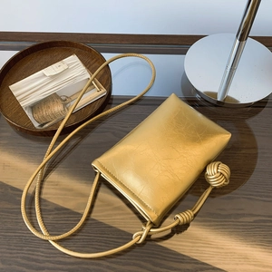 Chic golden pleated textured crossbody phone bag with stylish sphere knot strap details