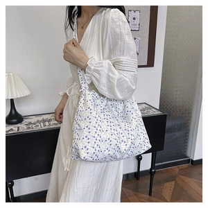 Floral canvas tote bag with drawstring closure shown in a lifestyle street fashion shot
