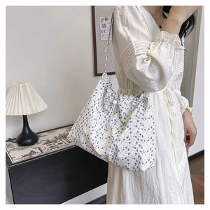 Close-up of floral tote bag with purple flower pattern and white drawstring closure