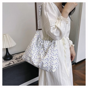 Detail of floral canvas tote bag showing drawstring closure and purple flower pattern