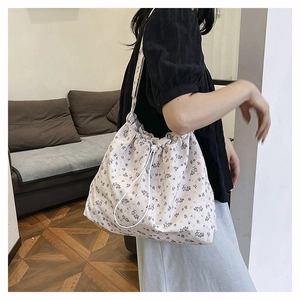 Detail of floral canvas tote bag with drawstring closure and comfortable shoulder strap