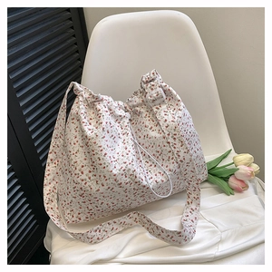 Close-up of floral canvas tote bag featuring a red flower pattern and drawstring closure