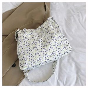 Detail of floral canvas tote bag showing lightweight fabric texture and wide shoulder strap