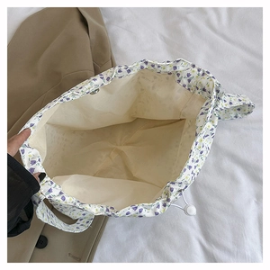 Close-up of floral canvas tote bag showing purple flower print and drawstring closure detail