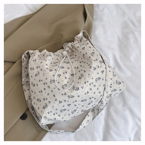 Detail of floral canvas tote bag showing drawstring closure and blue flower patterns