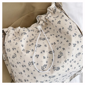 Detailed close-up of floral drawstring closure with white toggle on canvas tote bag