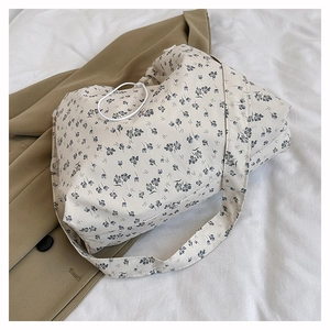 Close-up of floral canvas tote bag featuring blue flower patterns and white drawstring