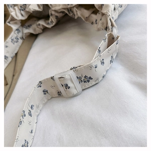 Detail of floral canvas strap with transparent plastic buckle and neat stitching