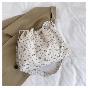 Detail of floral canvas tote bag with drawstring closure and blue flower patterns