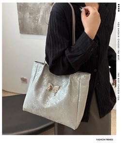 Détail du sac cabas argenté métallisé avec texture scintillante et boucle papillon