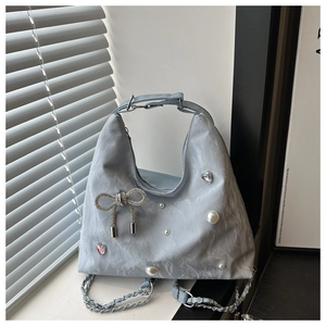 Detail of light blue pleated handbag featuring rhinestone bow and pearl charms