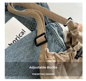 Dettaglio della fibbia nera regolabile e della tracolla sulla borsa beige casual