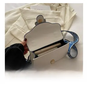 Interior view of white flap bag with canvas strap showing phone capacity and storage