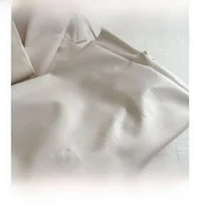 Detailed close-up of embossed W GONGZHU logo on creamy white leather tote bag texture