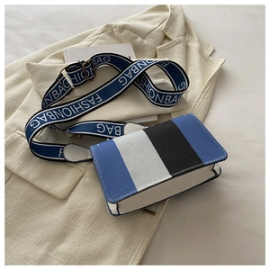 Detail of color-block flap bag with FASHIONBAG lettered wide shoulder strap on blazer
