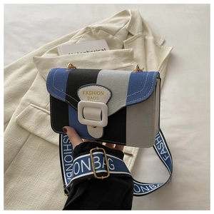 Detail of blue striped canvas crossbody bag with branded wide strap and gold hardware