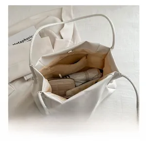 Spacious interior of minimalist beige tote showing umbrella and wallet storage