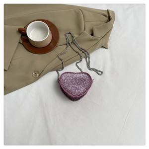 Detailed view of pink heart-shaped sequin mini bag with elegant silver chain strap