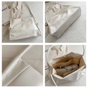 Detail view of cream white tote bag showing soft PU texture, embossed base, and interior space