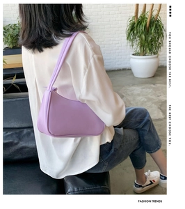 Lifestyle view of minimalist light purple faux leather shoulder bag worn by model