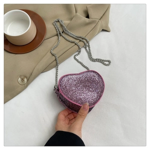 Detailed view of pink heart shaped crossbody bag with sequins and silver chain strap