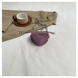 Top view of pink heart-shaped mini sequin bag with silver chain on white background