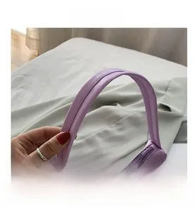 Detail view of purple faux leather handbag showing smooth handle stitching and texture