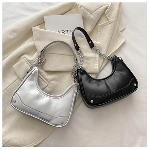 Detail of hobo bag with contrast straps, metallic chain, and silver rivet accents