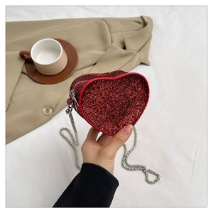 Detail shot of heart-shaped handbag featuring red rhinestones and silver chain strap