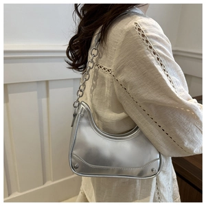 Silver metallic hobo bag with chunky chain strap worn over the shoulder by model